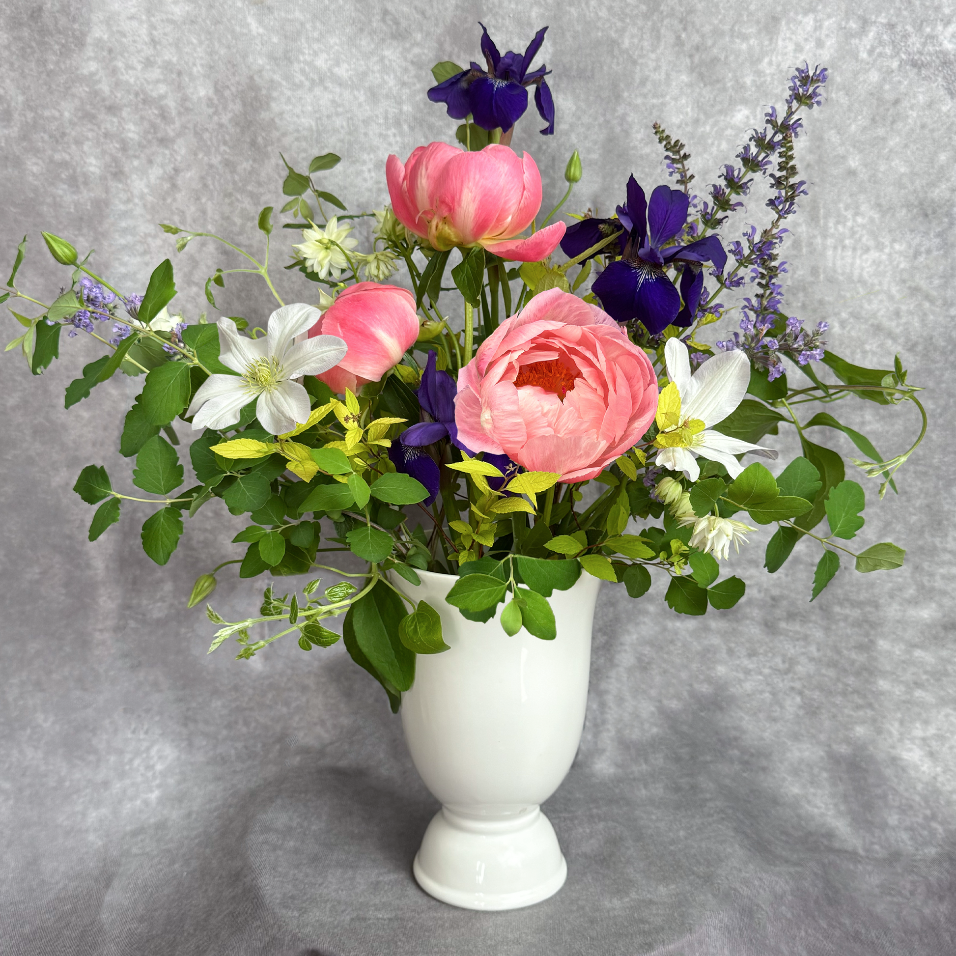 Bouquet of flowers in a white vase on a gray background