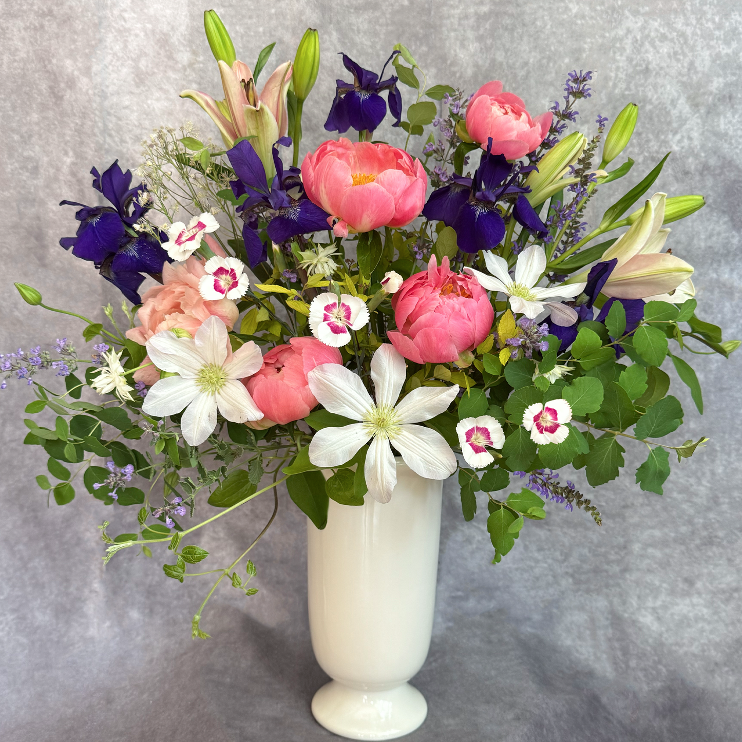 Bouquet of flowers in a white vase on a gray background