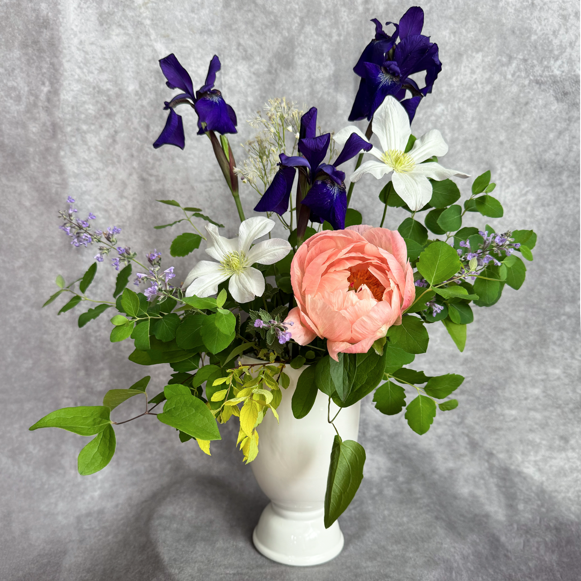 Bouquet of flowers in a white vase on a gray background