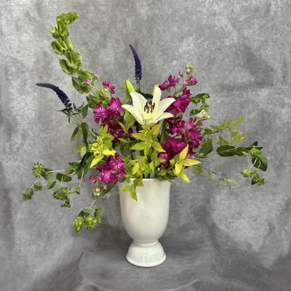 Floral arrangement in a white vase on a gray background