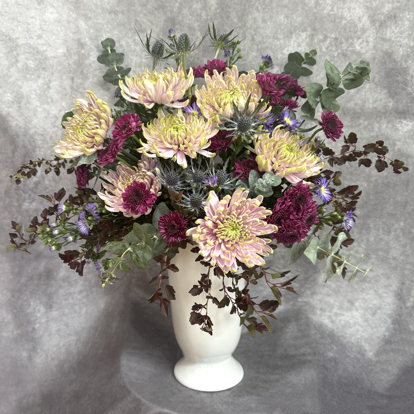 Bouquet of flowers in a white vase on a gray background