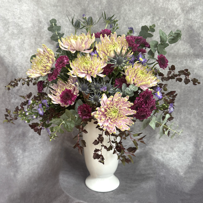 Bouquet of flowers in a white vase on a gray background