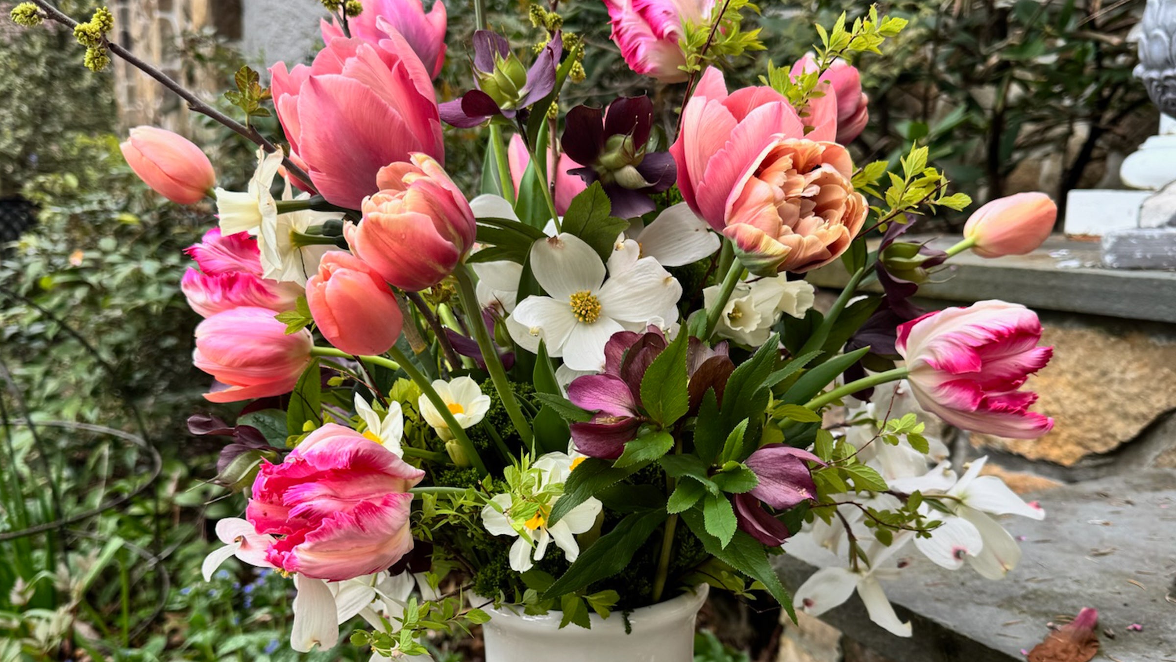 Bouquet of pink, white, and purple flowers in a pot with a blurred natural background
